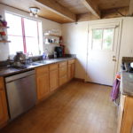 a kitchen in a home with hardwood floors and wooden cabinets