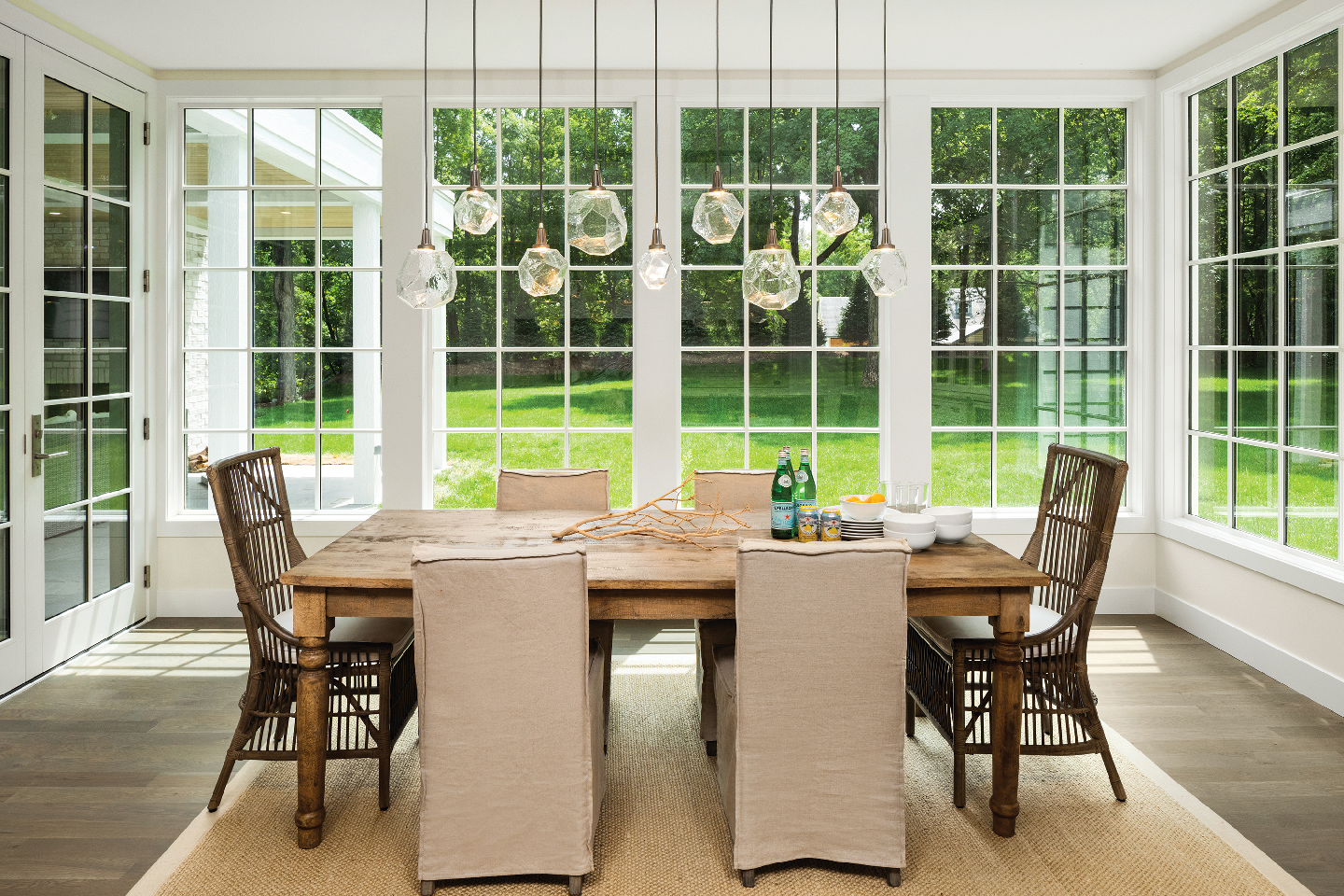 a dining room with windows all around, with a beautiful chandelier