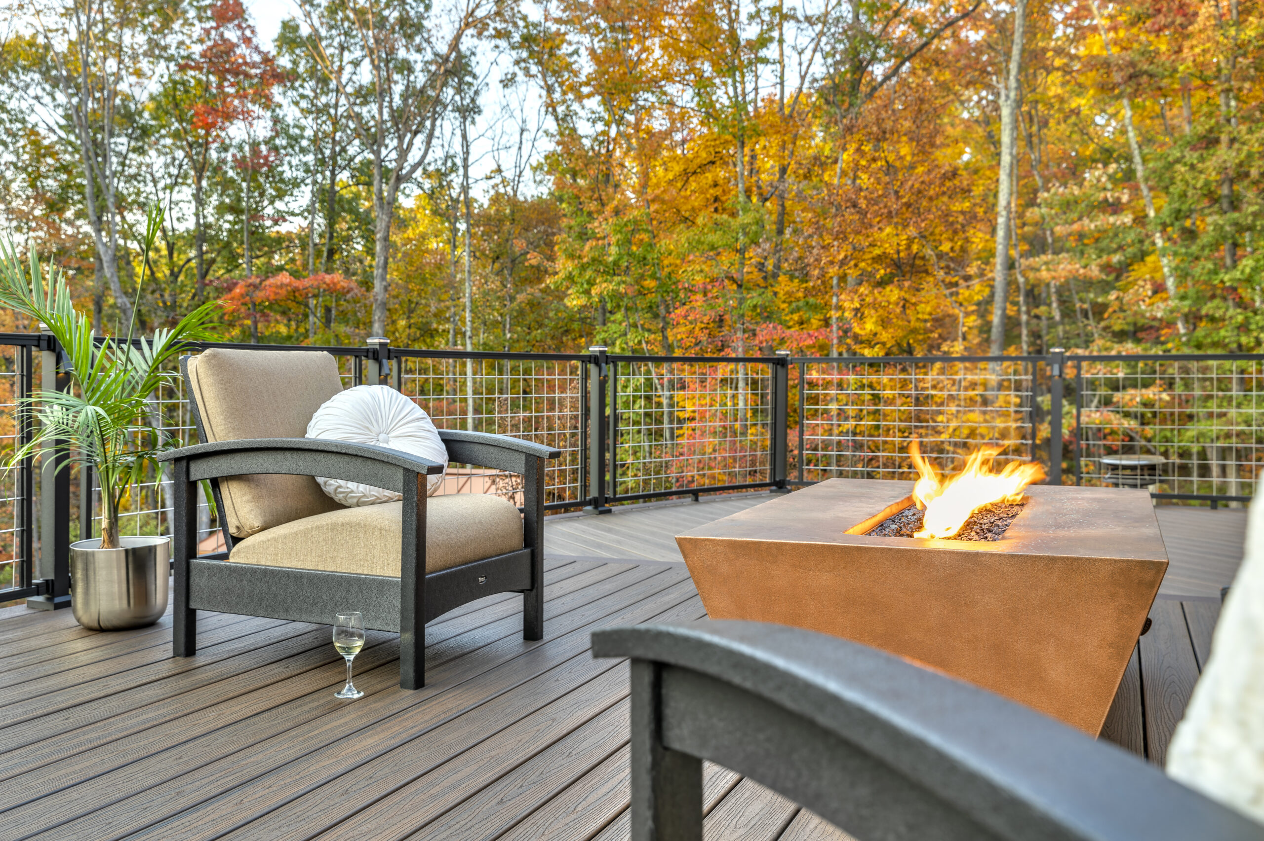 beautiful trex deck in an autumn landscape, with two chairs and a firepit table