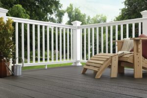 an outdoor deck with white railing, complete with a wooden adirondack lounge chair