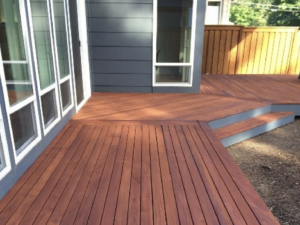 mahogany decking along a blue house 