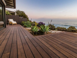 terraced bamboo decking surrounded by landscaping with a waterfront view 