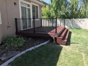 a newly built deck equipped with Cinch railing, surrounded by landscaping, in a fenced yard